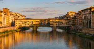 Ponte Vecchio bridge over Arno River in Florence at sunset with historic buildings