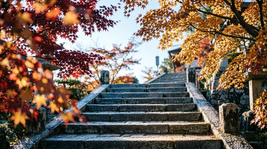 Red maple trees framing a stone temple pathway in Kyoto during mid-November