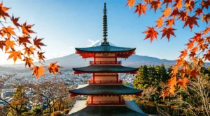 View of Mount Fuji and Chureito Pagoda framed by early autumn leaves in October.