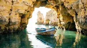 A wide view of the golden cliffs and turquoise water at Praia do Camilo in Lagos, Portugal.