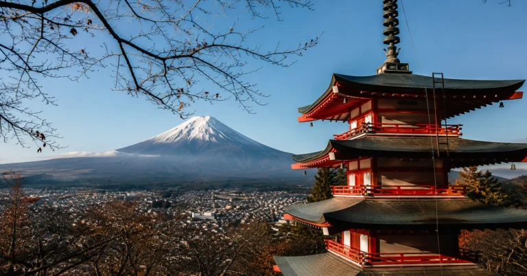 Mount Fuji snow-covered cone framed by the Chureito Pagoda under clear morning light.