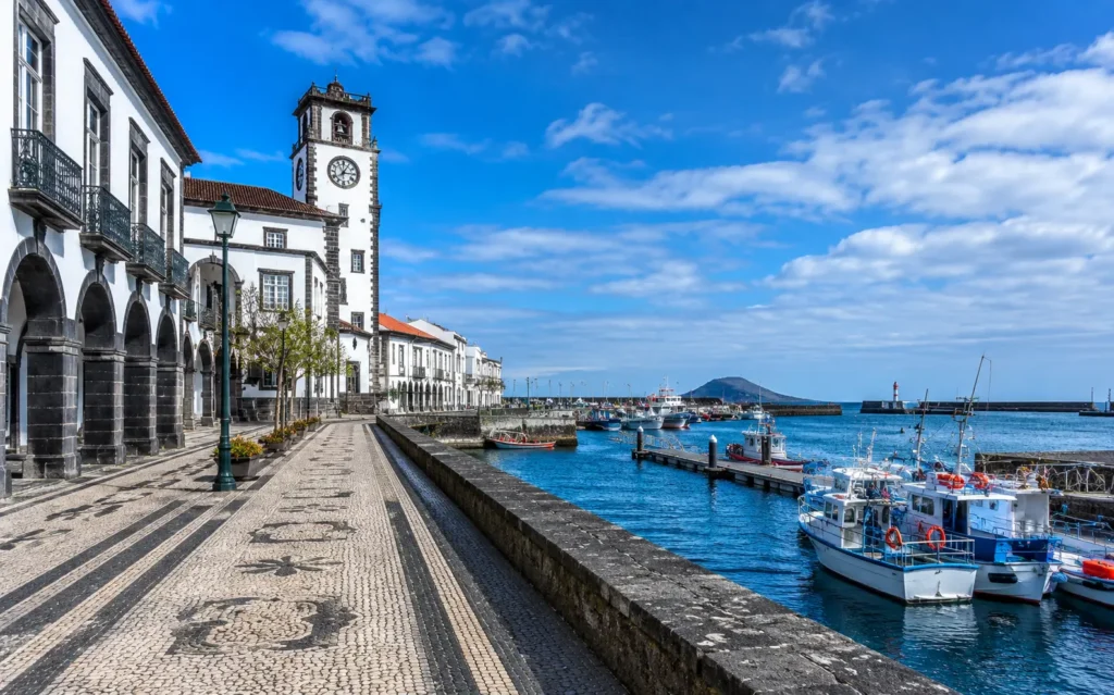 Street level view of Ponta Delgada harborfront displaying traditional Portuguese cobblestone pavements and stone arches