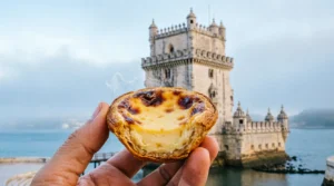 Ryan eating pastel de nata by Belem Tower Lisbon portugal on a budget.