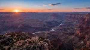 Grand Canyon South Rim panoramic vista looking toward the Colorado River during golden hour sunset.